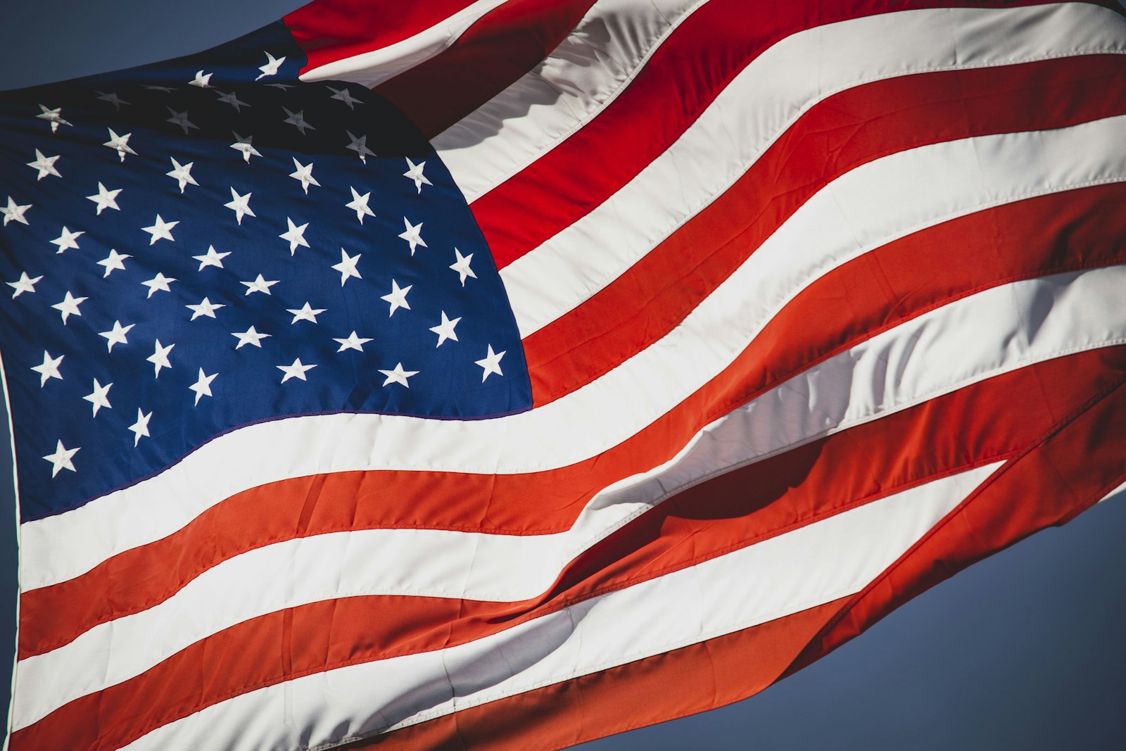 American flag waving against a deep blue sky